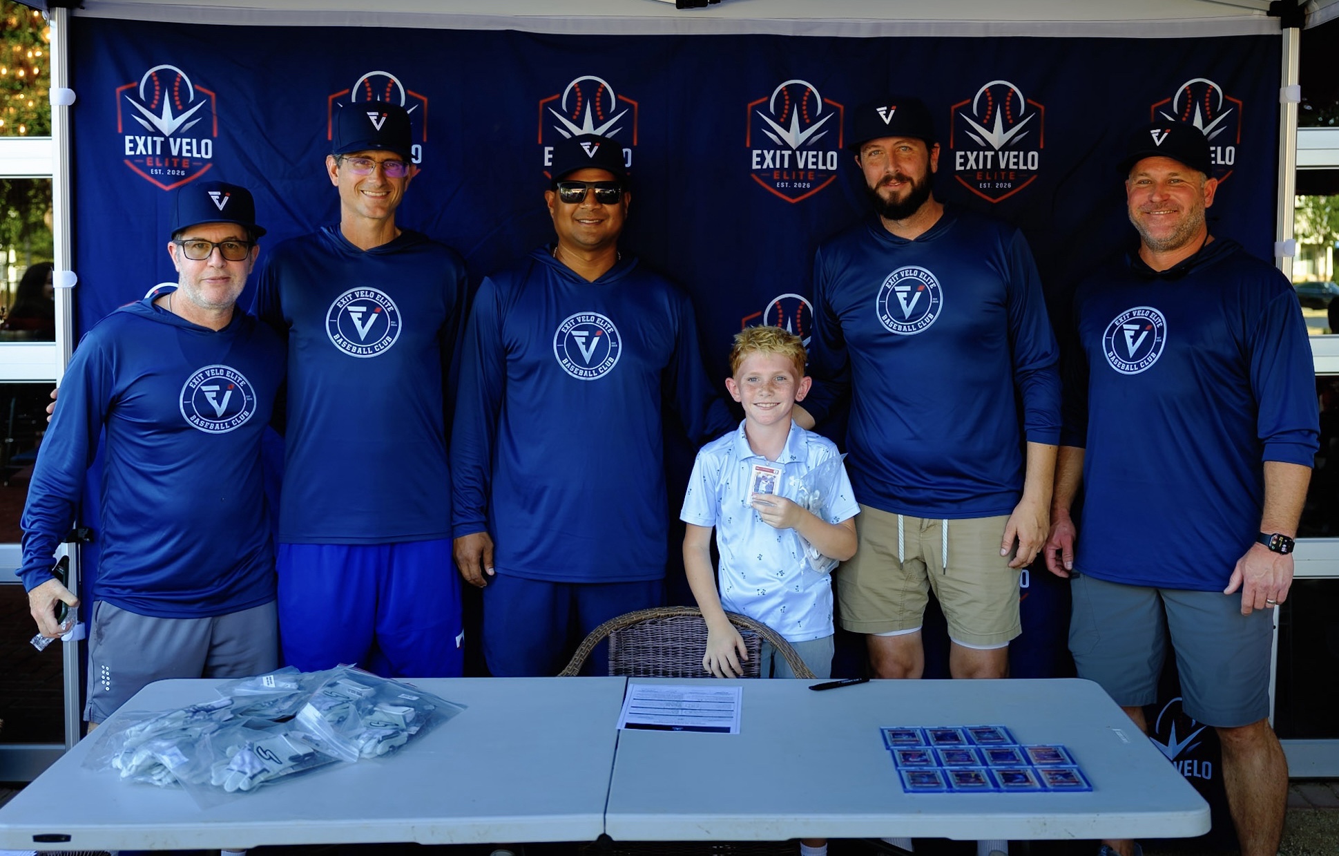 Coaches with a signee at the Exit Velo Elite tent