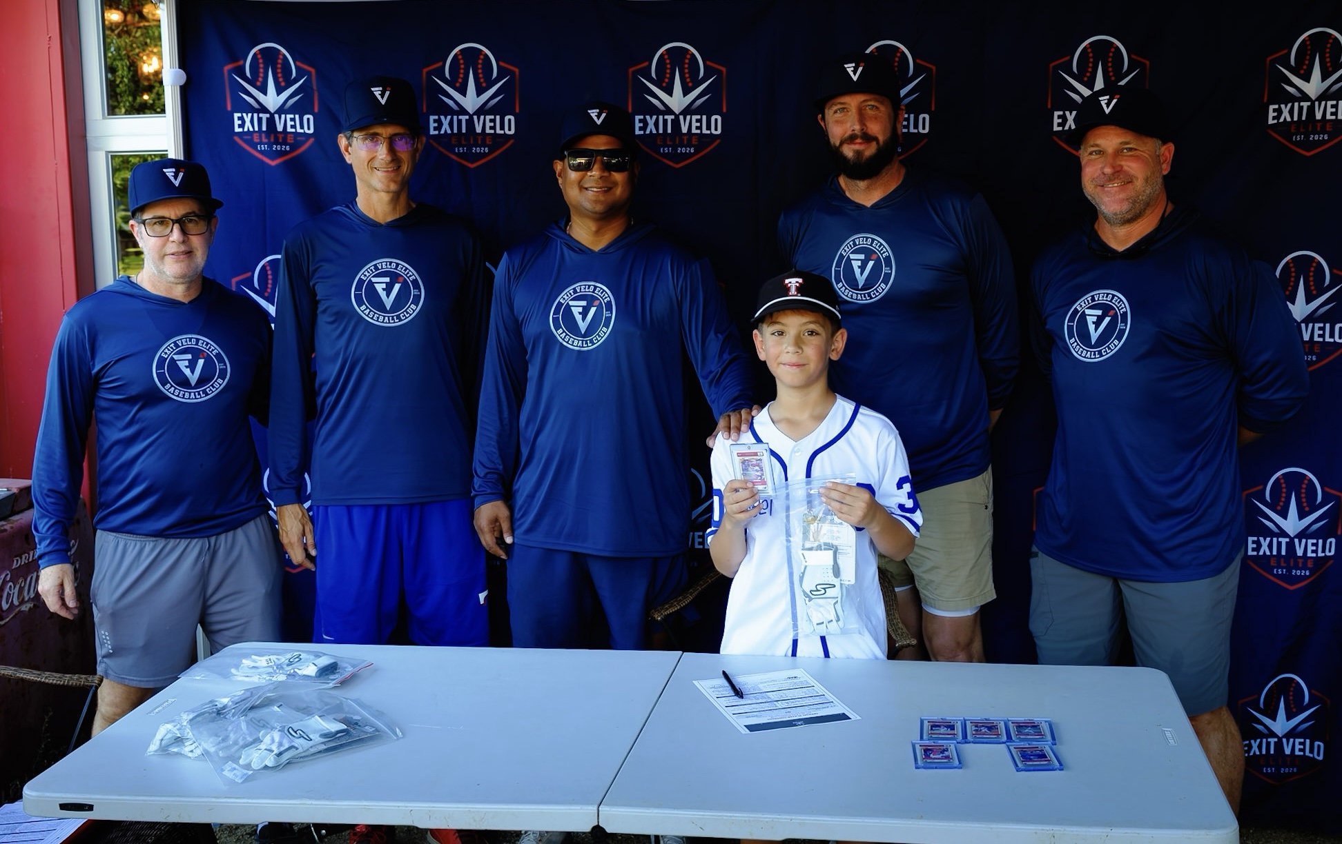 Coaching staff and a young player with his ZDecks card at the signing table