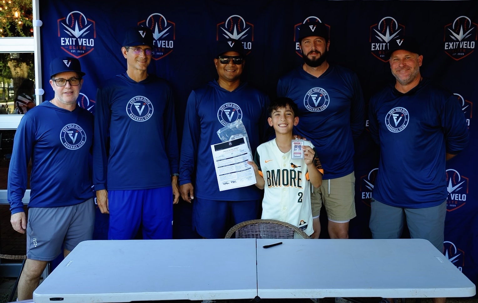 Coaching staff with a player at the signing table