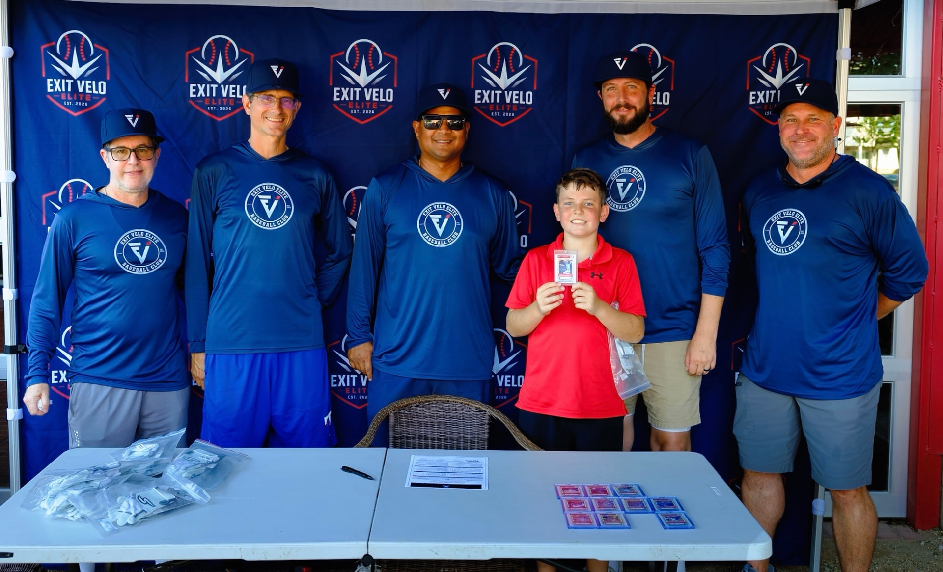 Coaching staff and a smiling signee holding his card