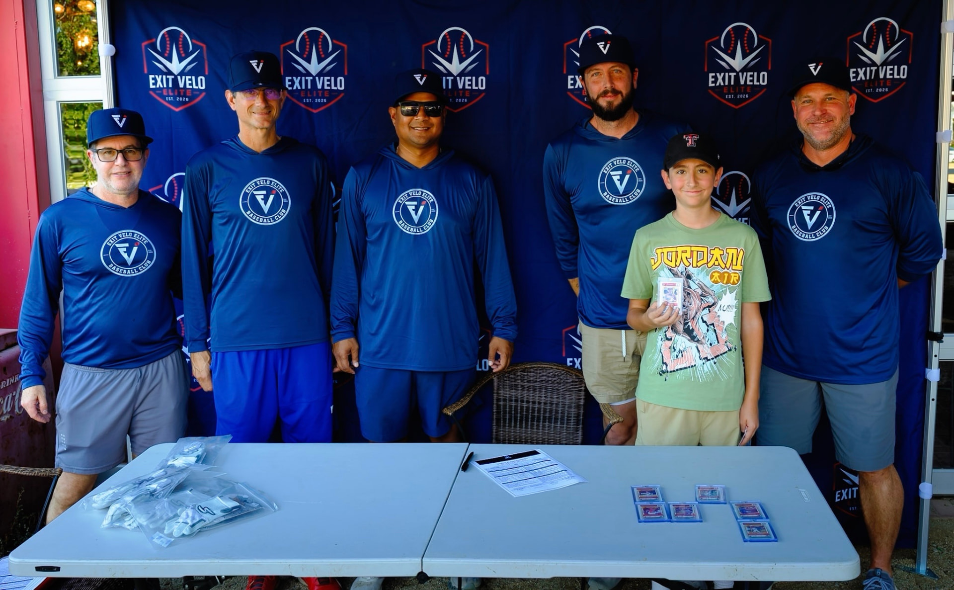 Coaching staff with a signee and graded cards on the table